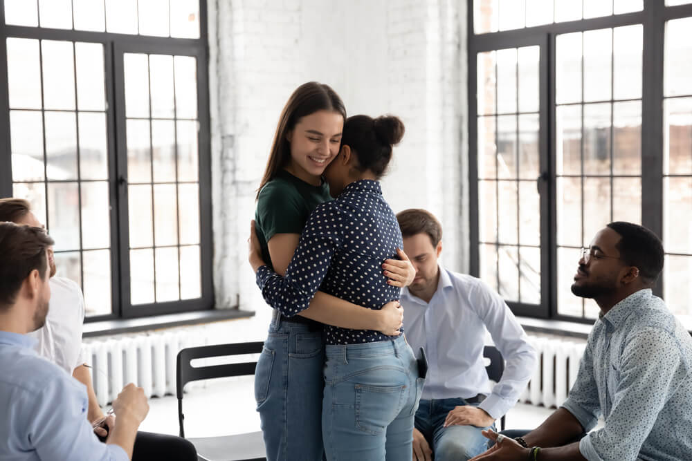 Woman hugging her fellow patient in a group session