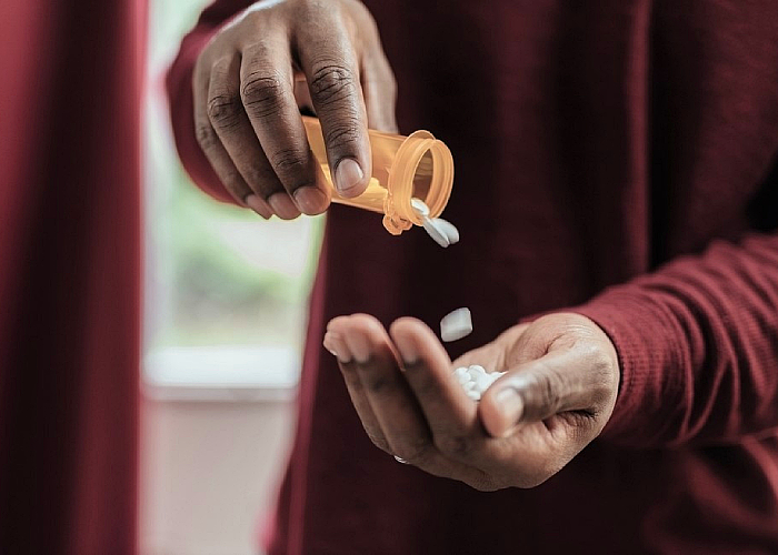 a man holding prescription pills