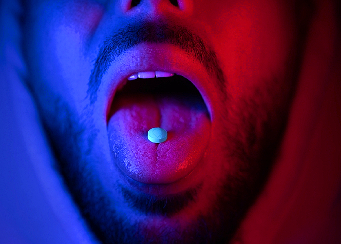 Ecstasy tablet in the mouth of a man