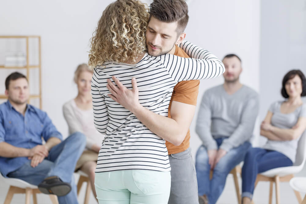 A male hugging his female colleague