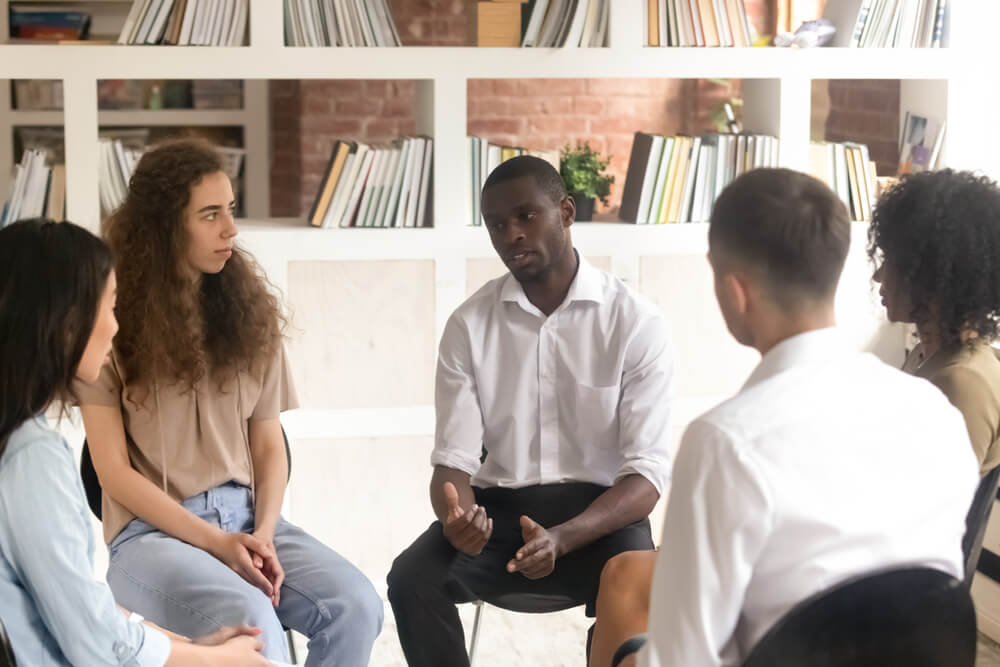 Man talking and explaining in a group session in rehab center