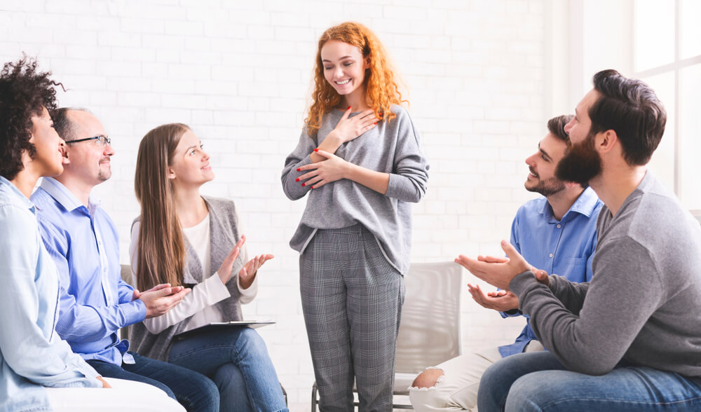 Woman standing in the middle of a group session