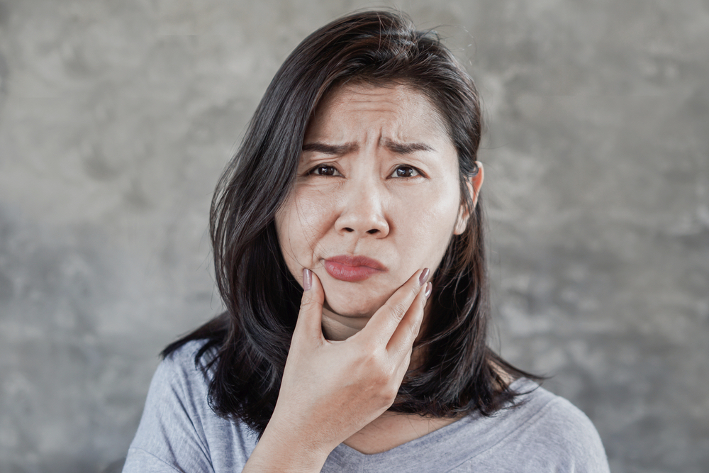 depressed woman having problem with her jaw