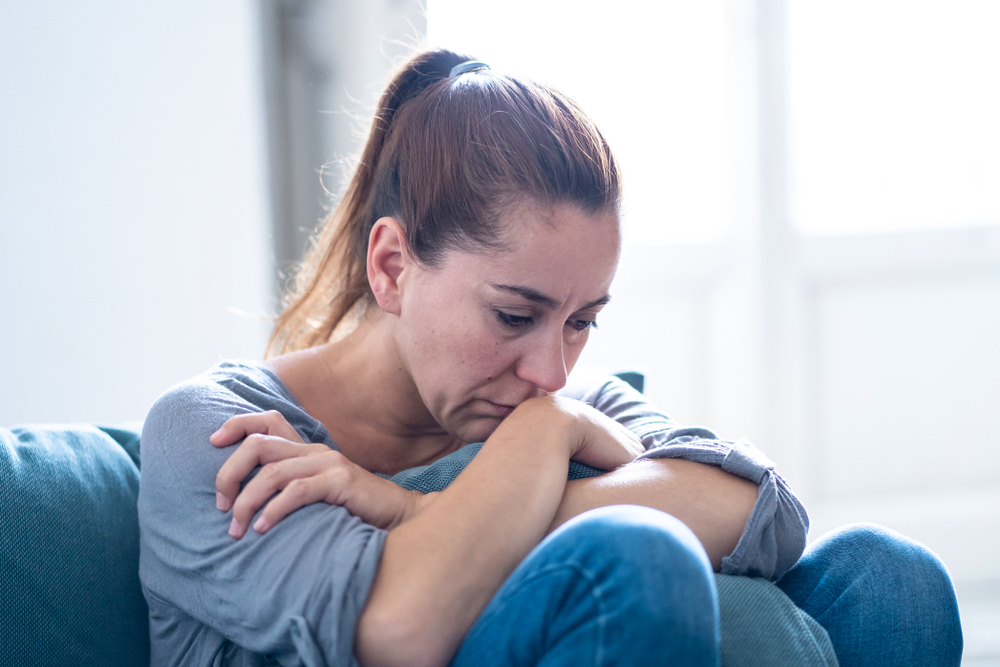 Troubled woman sitting in a Couche