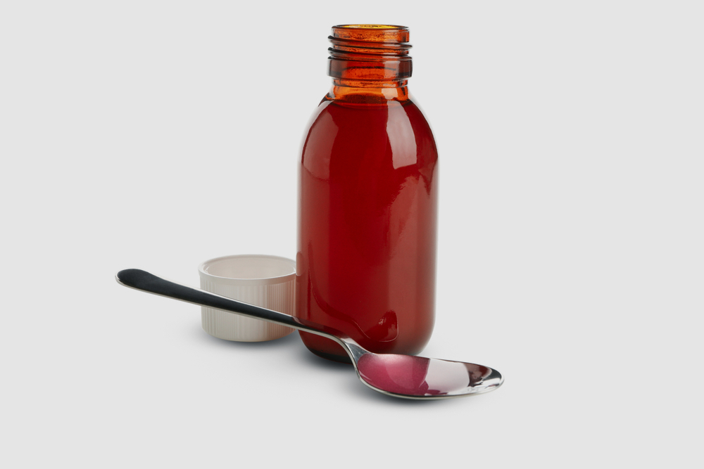 Medicine bottle and spoon with syrup