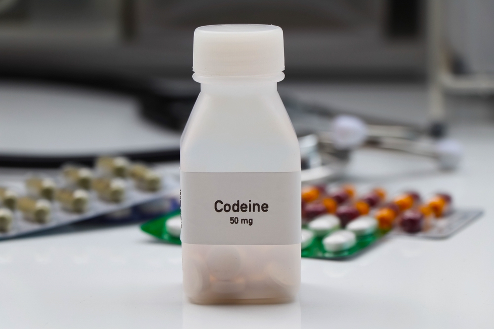 A bottle of Codeine with capsules behind