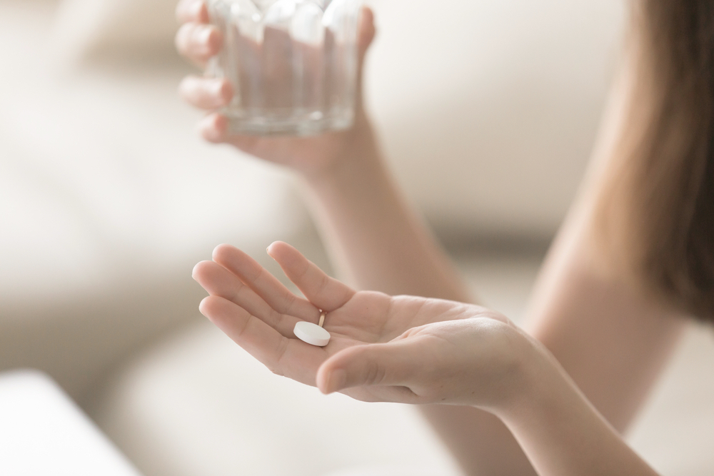 Woman preparing to drink naltrexone pills