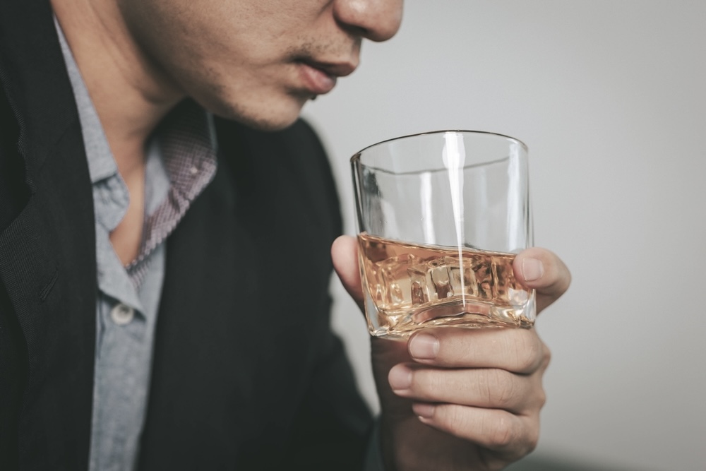 A man holding a glass of alcohol