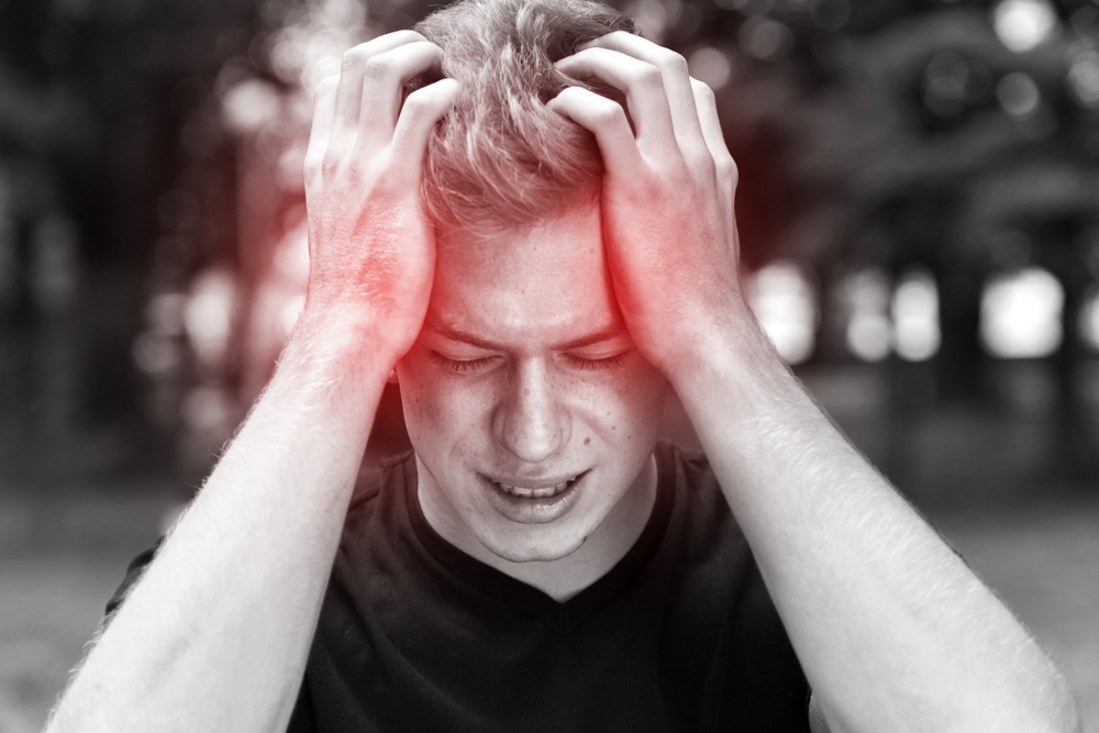 A man in black shirt having headache due to his cocaine addiction