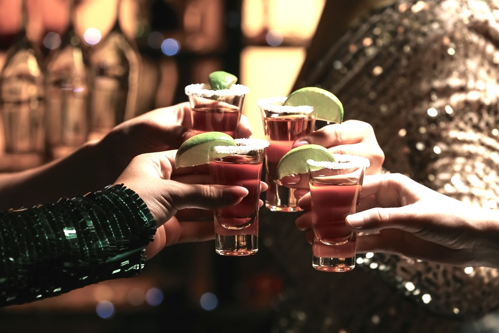 A group of friends having tequila shots in a bar