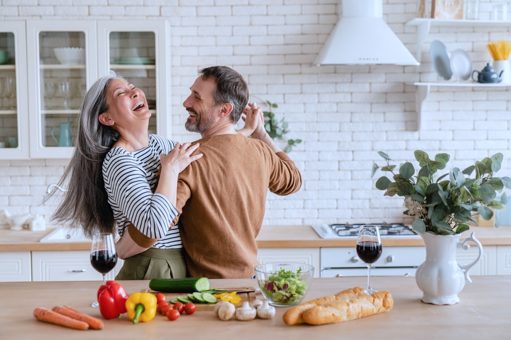 Elderly couple dealing with addiction recovery dancing in the kitchen