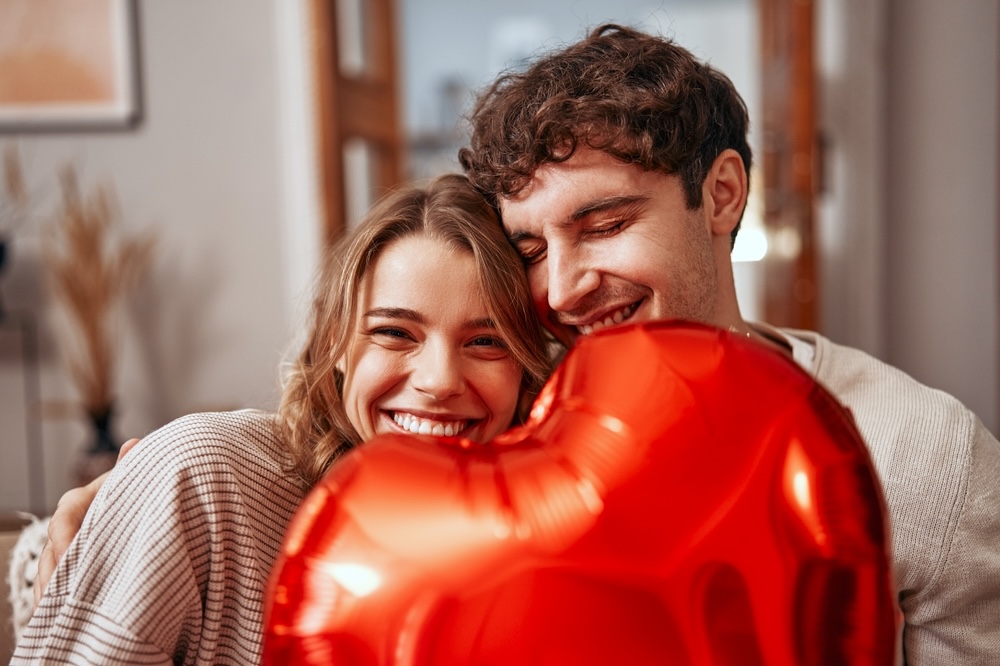 Husband and wife celebrating sobriety holding a red balloon