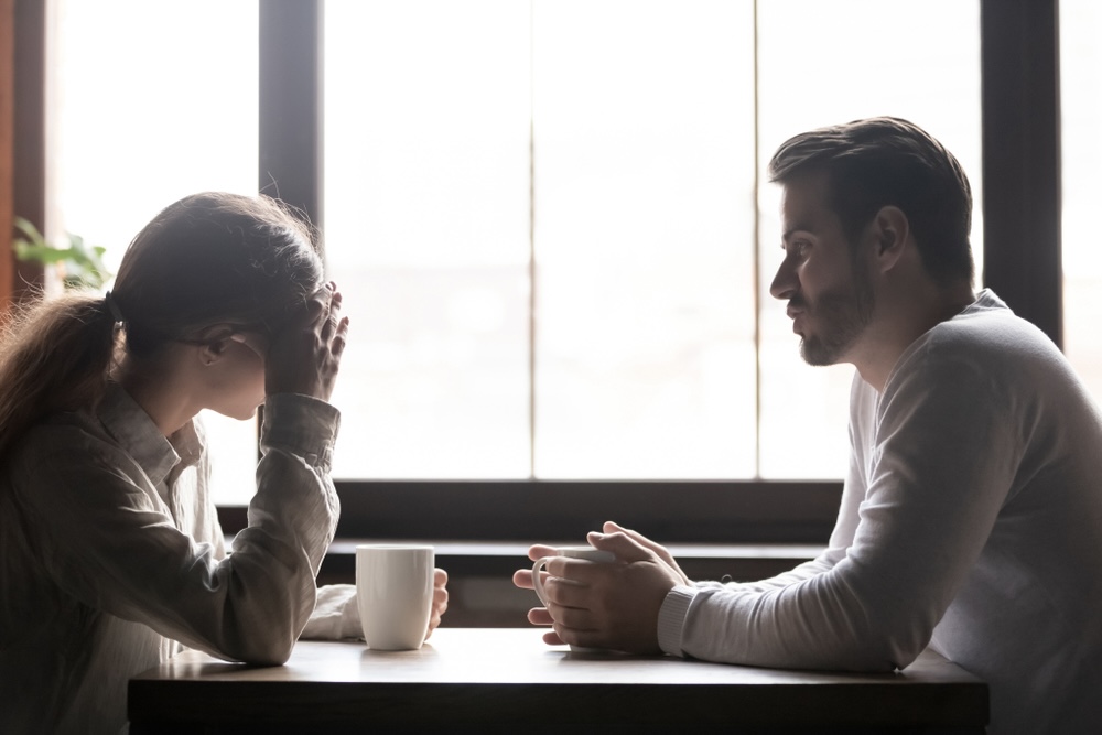 Man and woman talking in a cafe about addiction treatment and recovery