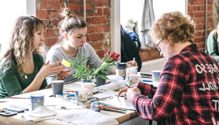 Group of people at the table at a painting class to boost their mental health