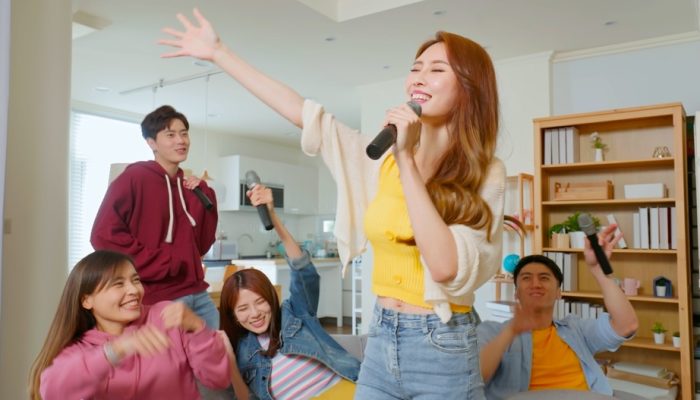 A group of friends singing karaoke in a room