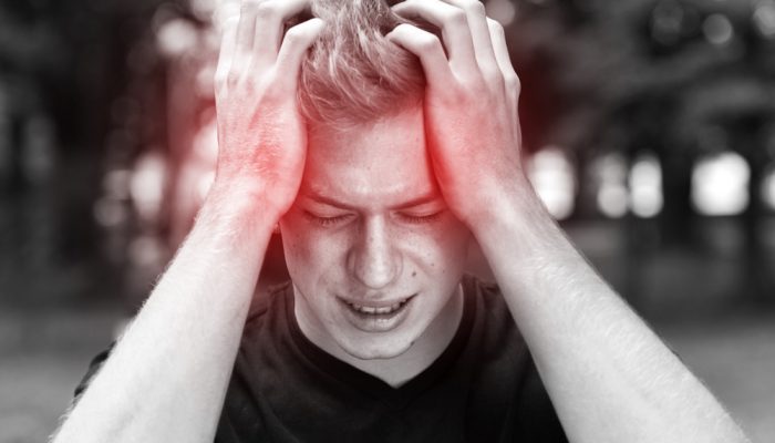 A man in black shirt having headache due to his cocaine addiction