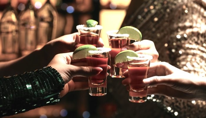 A group of friends having tequila shots in a bar