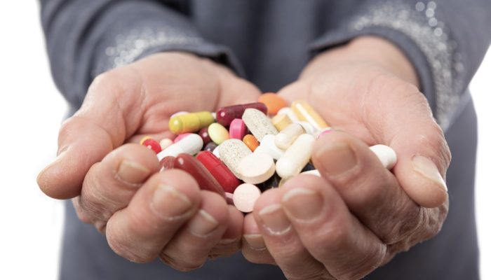 A man's hands full of anxiety medication pills